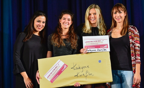 Vier junge Frauen stehen nebeneinander, lächeln und halten einen Preis für einen Kurzfilm in den Händen.