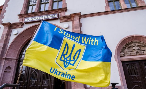 Eine Ukraineflagge mit der englischen Aufschrift "I stand with Ukraine" weht vor der Leipziger Kongresshalle.