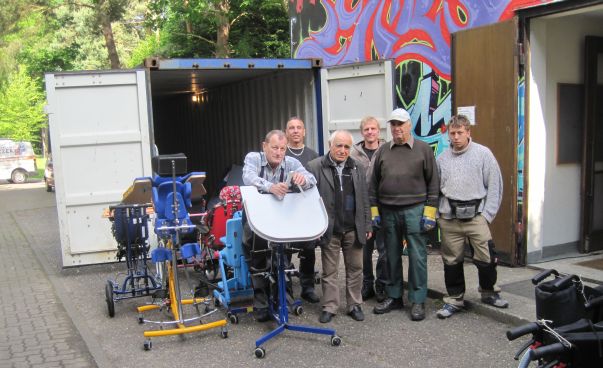 The picture shows a group of men who stand in front of a truck with medical devices.