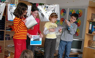 Vier Kinder präsentieren ein Projekt in ihrer Schulkasse
