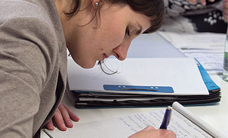 Bild einer jungen Frau, die sich Notizen macht.
