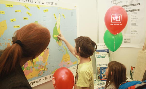 Kinder vor umgedrehter Weltkarte.