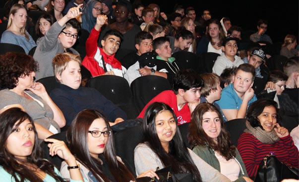 Jugendliche sitzen im Kinosaal.