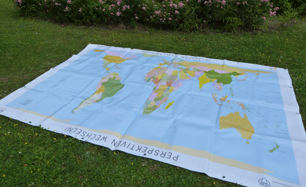 Das Foto zeigt die Weltkarte als Plane auf einer Wiese liegend.