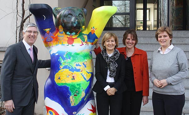 Zwei Mitarbeiterinnen mit der portugiesischen Staatssekretärin und dem Botschafter von Portugal stehen neben einem Berliner Bär. Foto: Paula van Aken