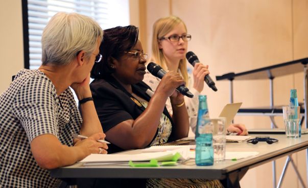 Drei Frauen sitzen an einem Tisch und sprechen mit Blick in den Raum in Mikrofone. Foto:WECF e.V.