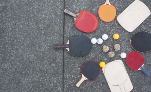 Tischtennisschläger liegen auf einer Tischtennisplatte.