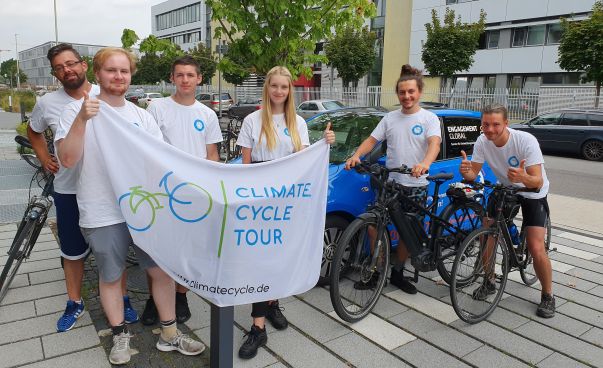 Die Teilnehmerinnen und Teilnehmer der Fahrradtour halten einen Banner mit der Aufschrift Climate Cycle Tour in den Händen. Foto: Engagement Global
