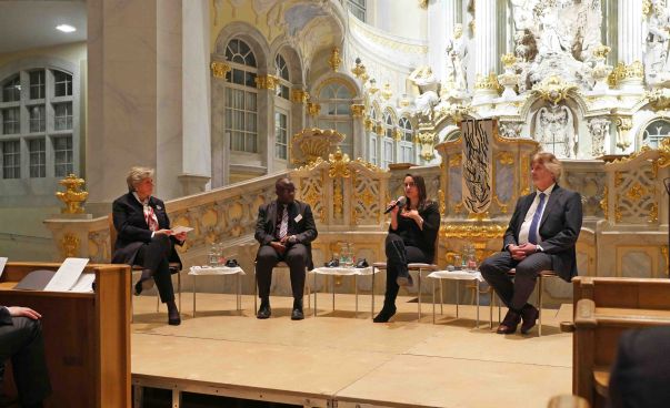 Vier Personen sitzen auf Stühlen in der Dresdner Frauenkirche. Foto: Stiftung Entwicklung und Frieden