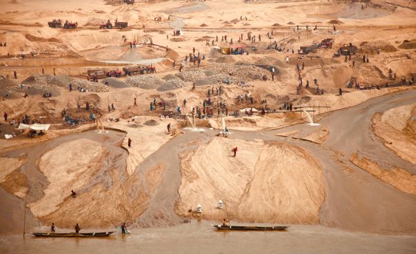 Arbeiterinnen und Arbeiter bauen Sand ab.
