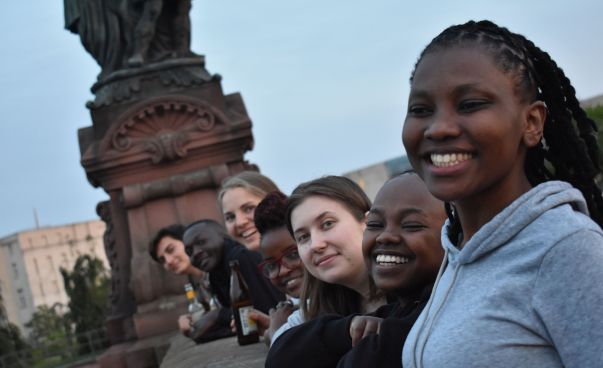 Eine Gruppe von Jugendlichen posiert auf einer Brücke für ein Foto.