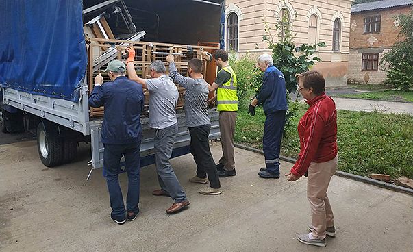 Männer packen Güter in einen Lastwagen.
