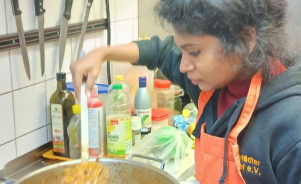 Eine junge Frau kocht in einer Küche.