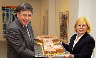 Ronald Grätz und Gabriela Büssemaker halten gemeinsam einen Kuchen in Schlüsselform.