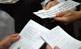 Workshopteilnehmer halten ihre Notizen in den Händen.