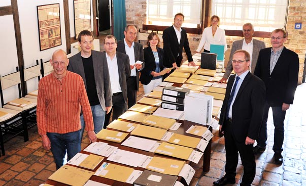 Das Bild zeigt die Jurymitglieder vor den Unterlagen.