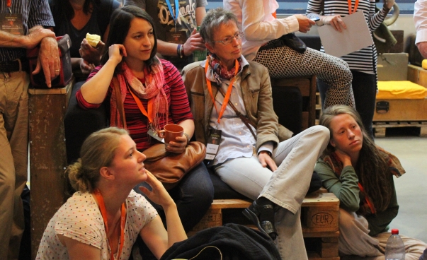 Teilnehmende des NachhaltigkeitsCamps Bonn 2017 sitzen in einem Kreis zusammen.