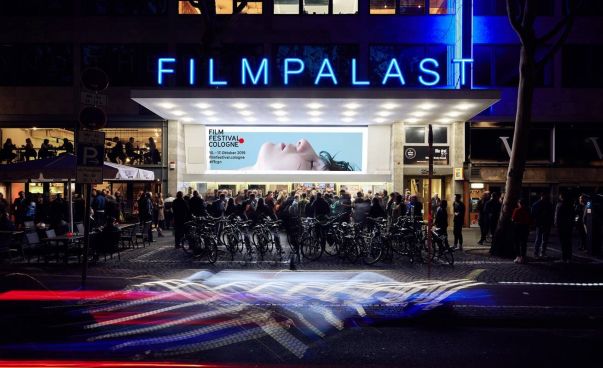 Die Außenansicht des Filmpalastes mit wartenden Menschen vor dem Kino. An der Wand hängt das Plakat zum Film Festival Cologne 2019. Foto: Film Festival Cologne