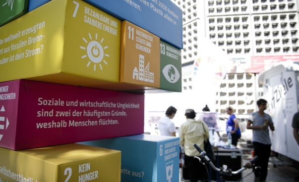 Im Vordergrund das SDG-Jenga-Spiel, im Hintergrund eine Gruppe von Menschen