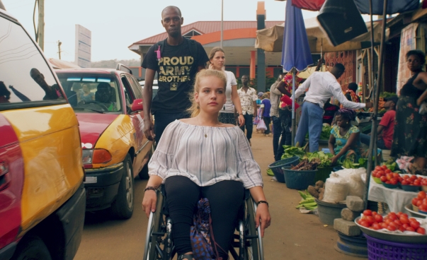 Junge Frau im Rollstuhl auf einem Markt in Ghana.