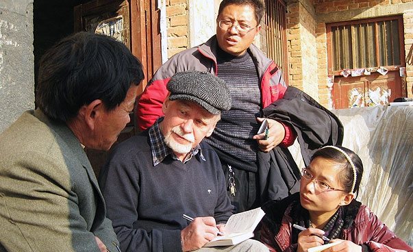 Ein Projektteilnehmer vom SES in China im Gespräch mit einer Familie.