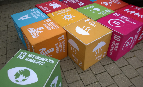 Sitzwürfel mit den Symbolen der 17 Ziele für nachhaltige Entwicklung liegen auf dem Boden. Foto: Engagement Global