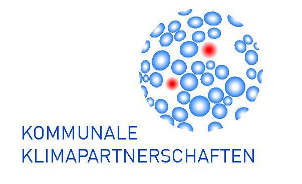 Das Logo der Kommunalen Klimapartnerschaften zeigt den Schriftzug und die grafische Darstellung einer Weltkugel, die aus blauen Elementen und zwei roten Markierungen besteht.